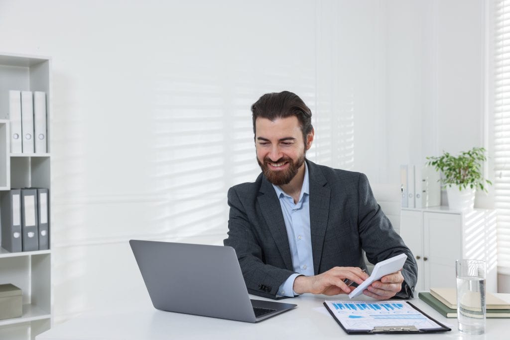 Finance professional in Singapore office reviewing digital expense claims dashboard on laptop.