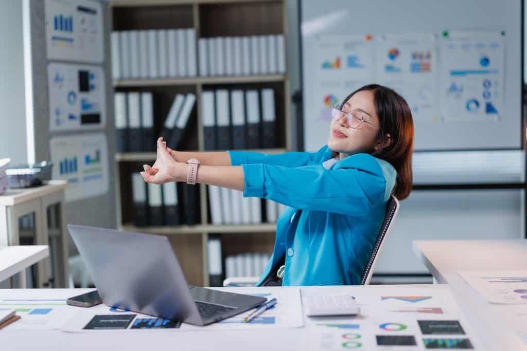 Employee relaxing from work after submitting her annual leave request on an online leave management system.
